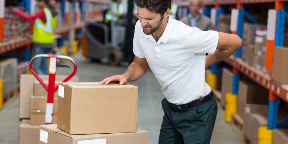 Male worker suffering from back pain while working