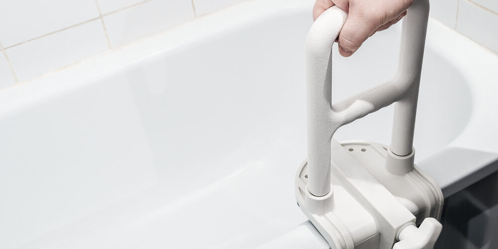 hand holding the handrail in the bathroom