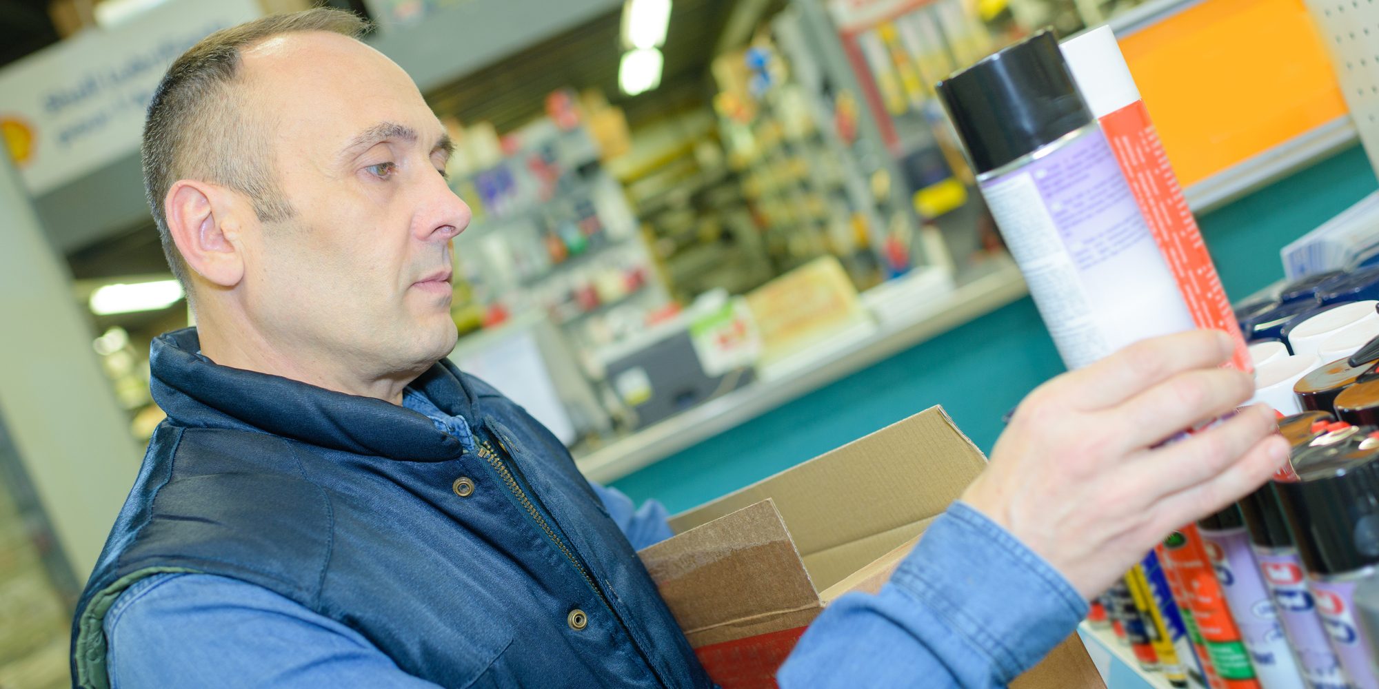 man choosing products for body care at supermarket