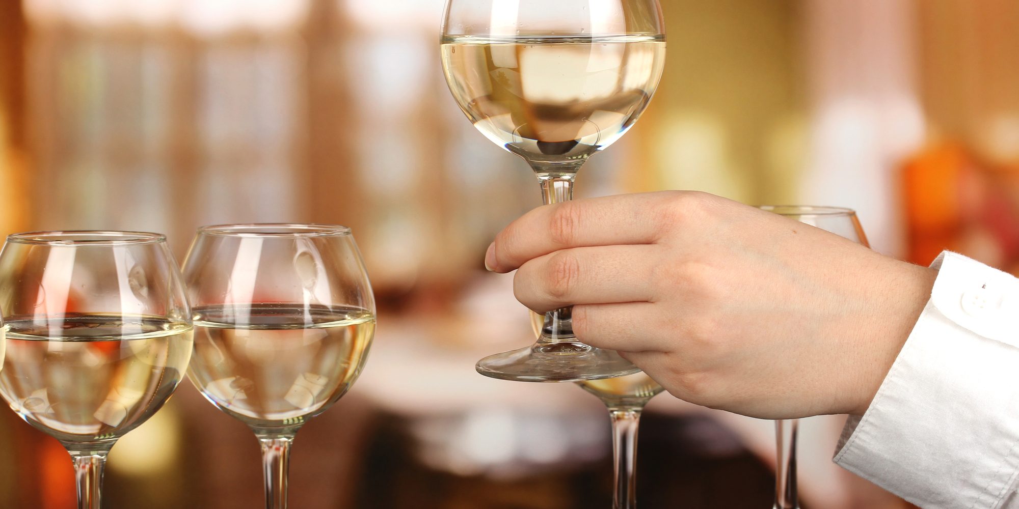 Tasting white wine on room background