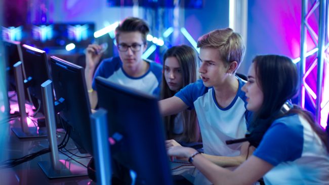 Team of Professional Boys and Girls Gamers Actively Thinking/ Di